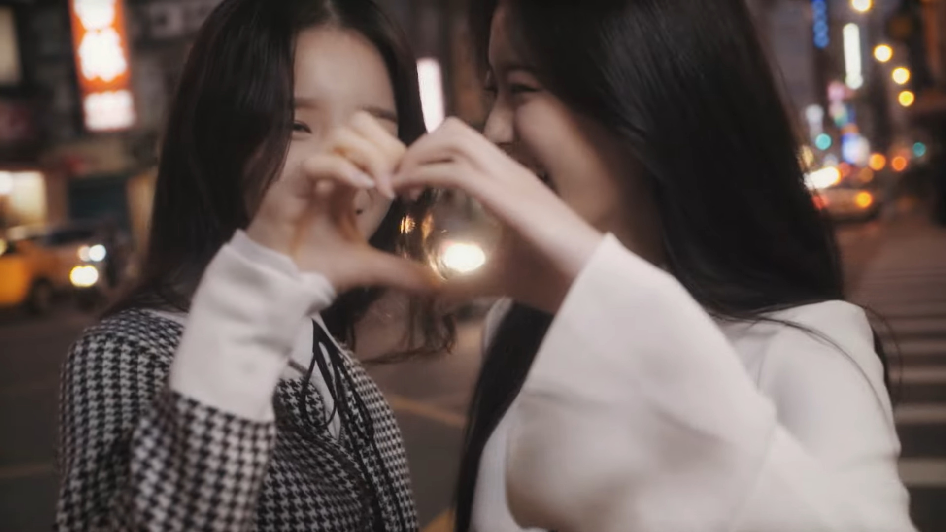 Heejin and Hyunjin making a heart with their hands.